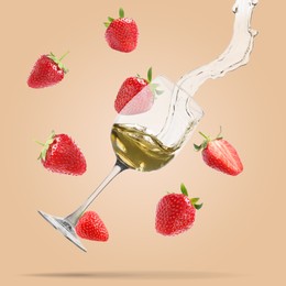 Image of Wine in glass and fresh strawberries falling against pink beige background