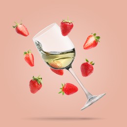 Image of Wine in glass and fresh strawberries falling against pink background