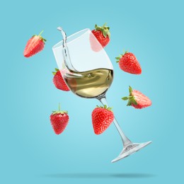 Image of Wine in glass and fresh strawberries falling against light blue background