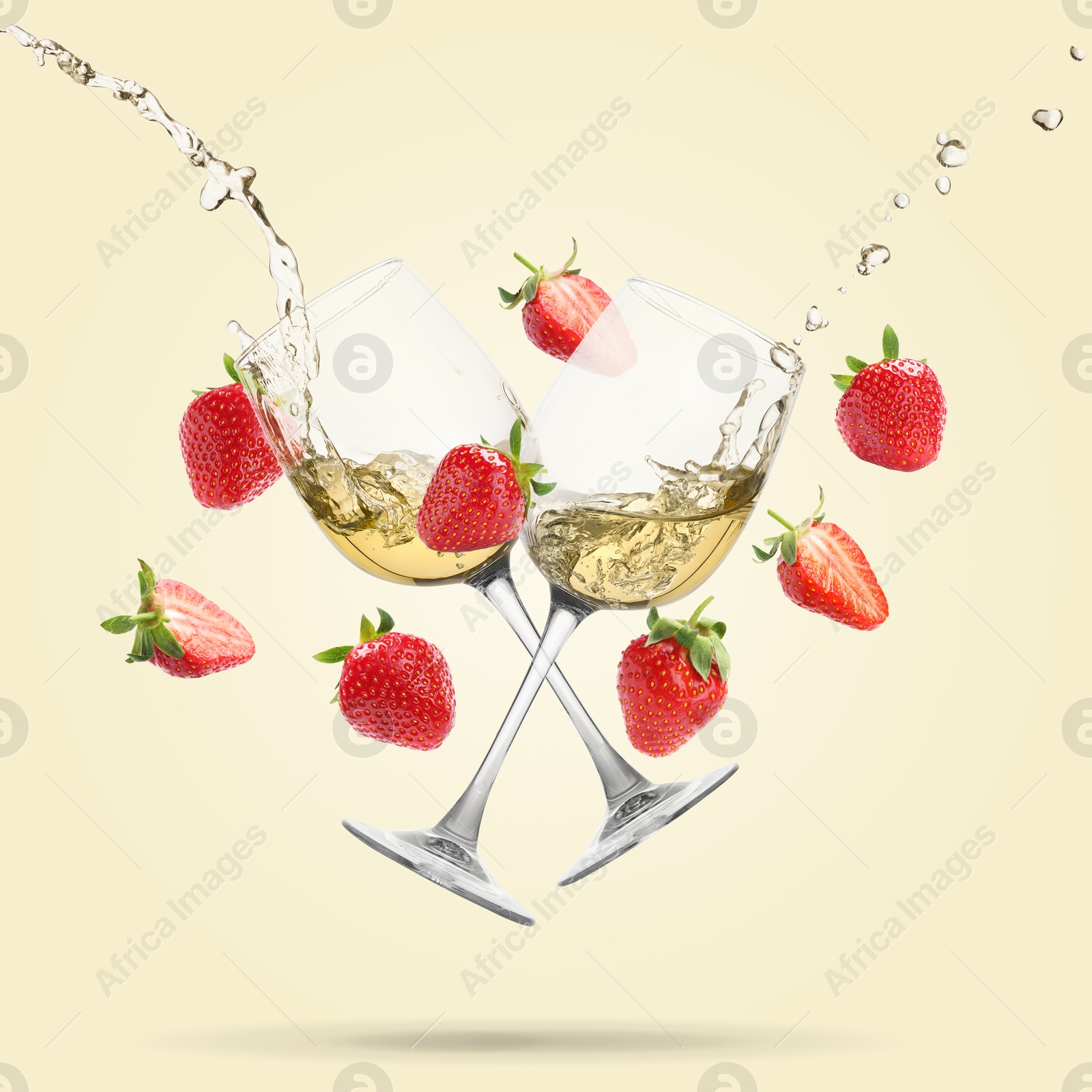 Image of Wine in glasses and fresh strawberries falling against beige background