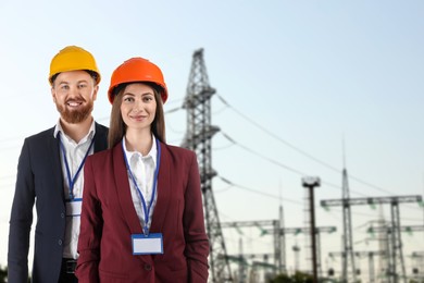 Image of Power engineers in hard hats against electrical substation