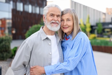 Photo of Lovely senior couple walking together on city street