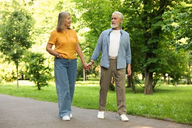 Photo of Lovely senior couple walking together in park
