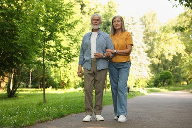 Photo of Lovely senior couple walking together in park