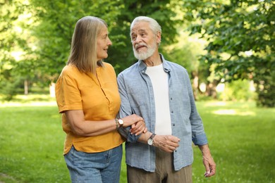Photo of Lovely senior couple walking together in park