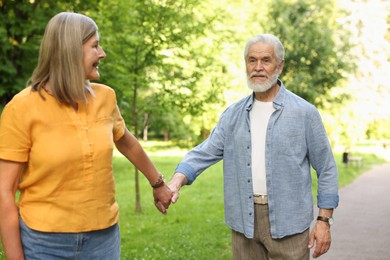 Photo of Lovely senior couple walking together in park