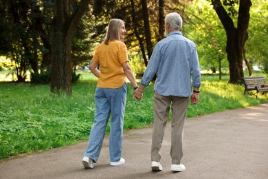 Photo of Lovely senior couple walking together in park