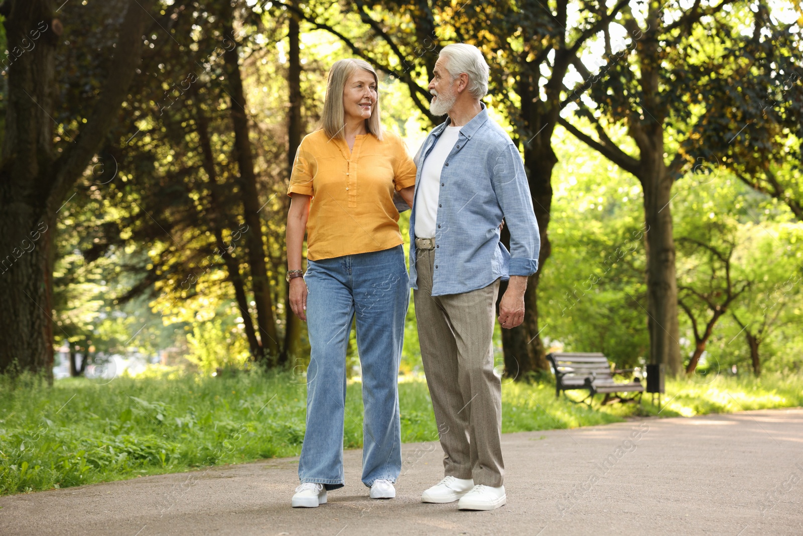 Photo of Lovely senior couple walking together in park