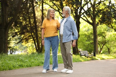 Photo of Lovely senior couple walking together in park
