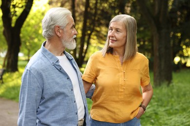 Photo of Lovely senior couple walking together in park