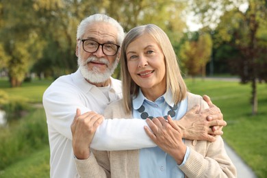 Photo of Lovely senior couple walking together in park
