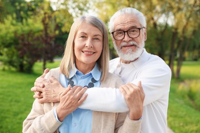 Photo of Lovely senior couple walking together in park