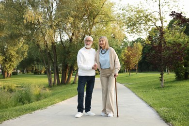Photo of Lovely senior couple walking together in park