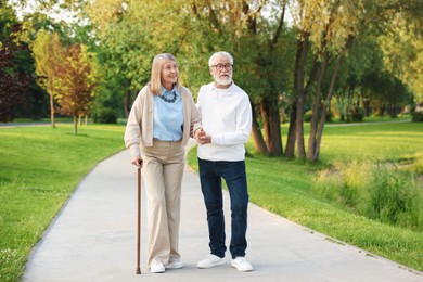 Photo of Lovely senior couple walking together in park