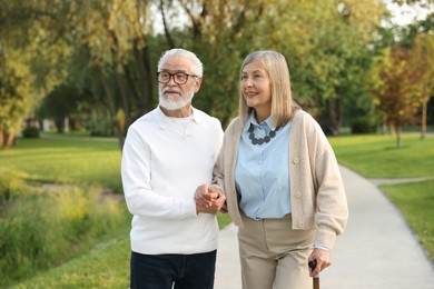 Photo of Lovely senior couple walking together in park