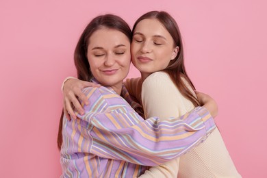 Photo of Friends hugging each other on pink background
