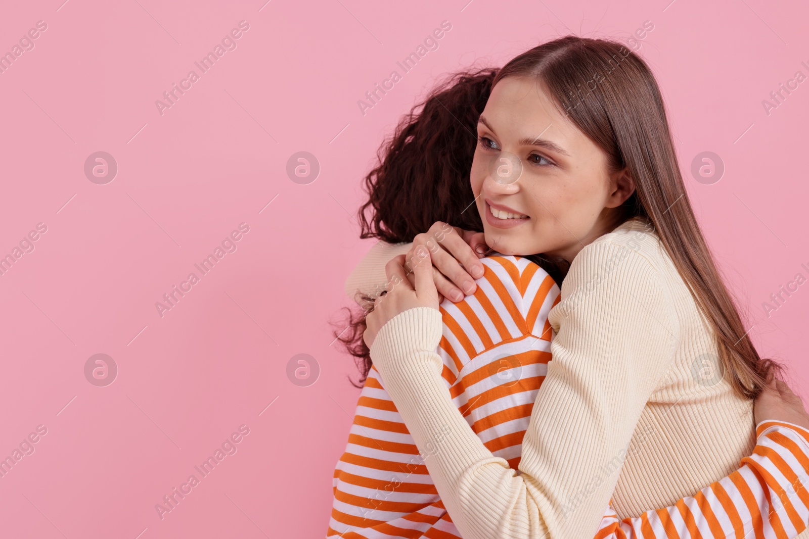 Two happy friends hugging on pink background, space for text Photo of Two happy friends hugging on pink background, space for text