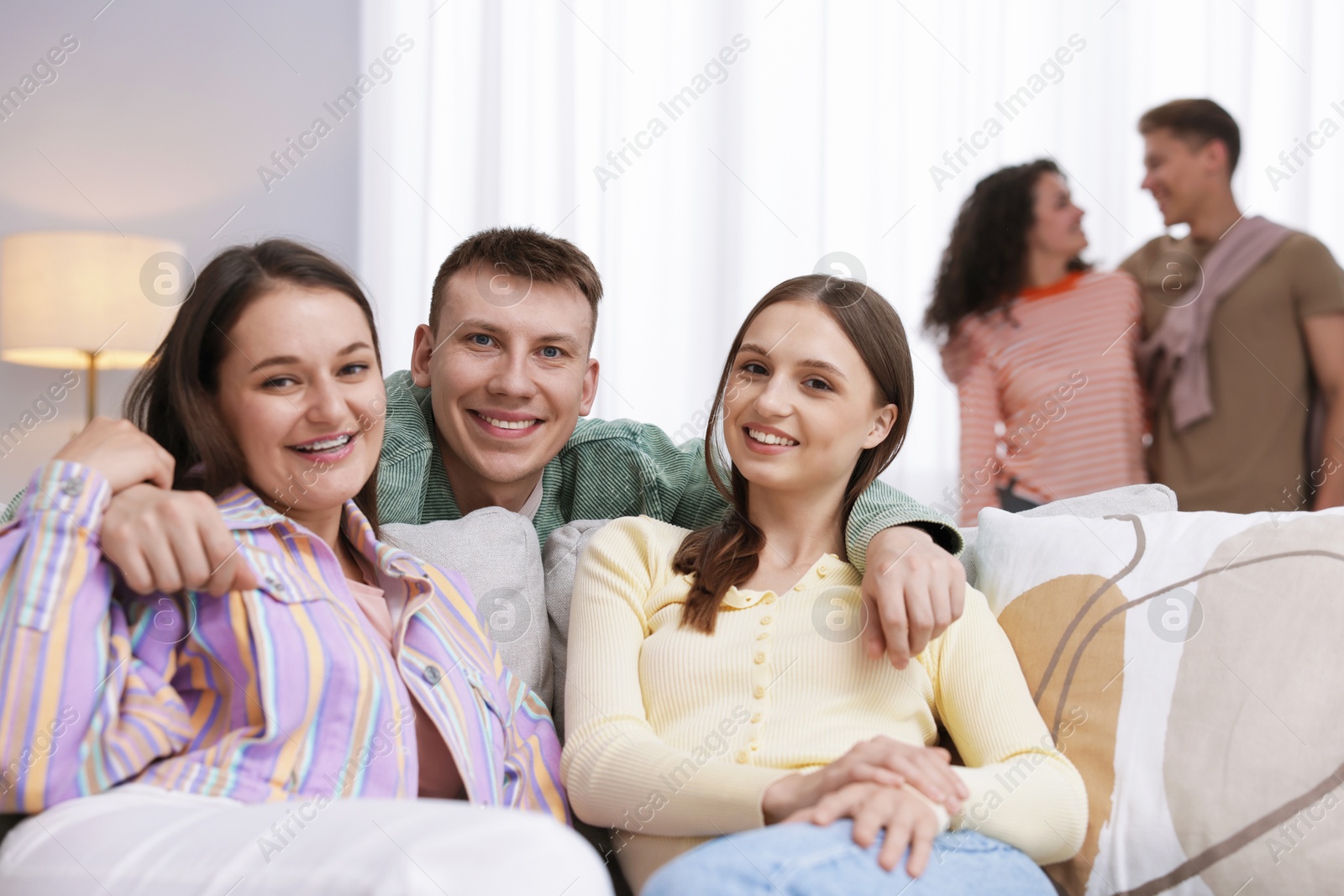 Photo of Friends hugging each other indoors, selective focus