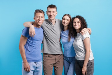 Photo of Group of friends hugging on light blue background