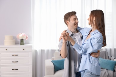 Photo of Happy couple dancing at home. Space for text