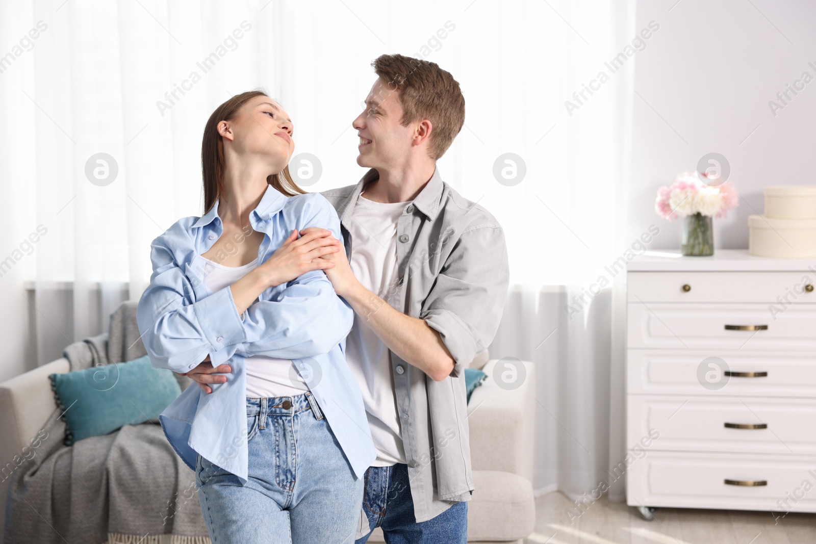 Photo of Happy couple dancing at home. Space for text