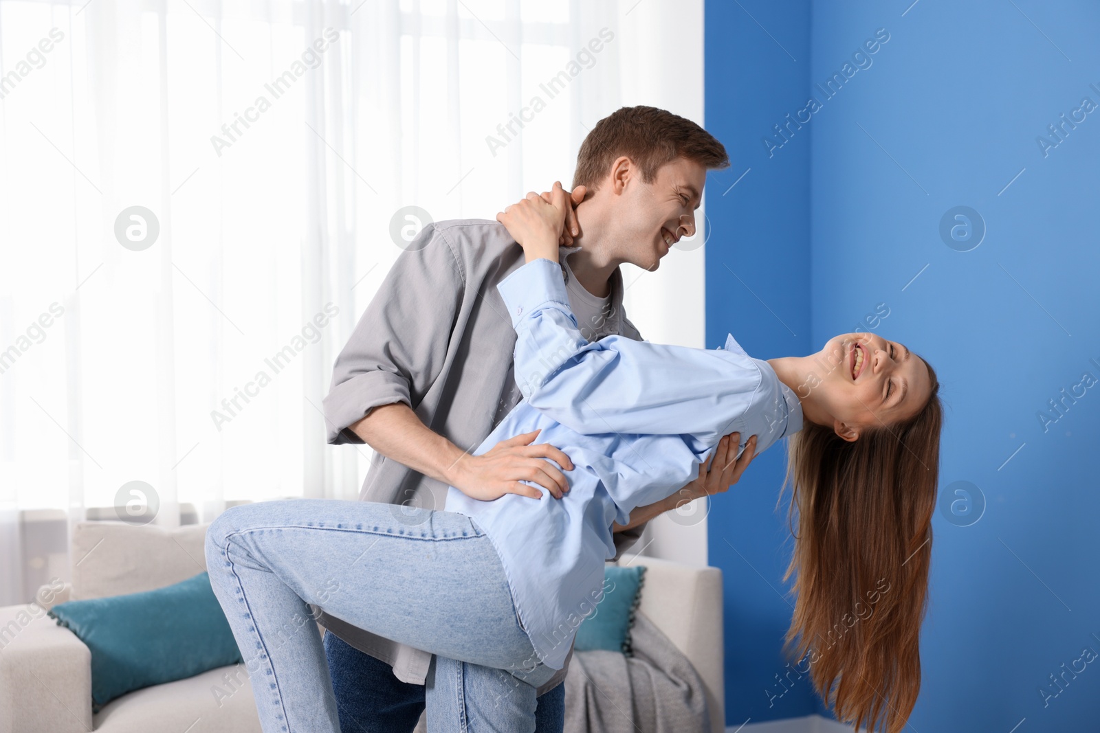 Photo of Happy young couple dancing together at home