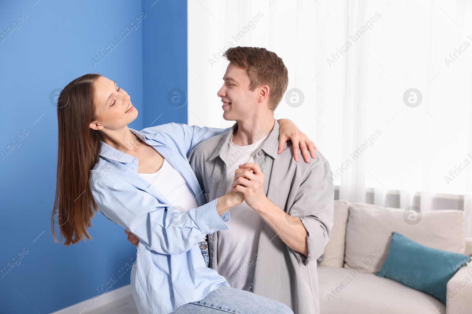 Photo of Happy young couple dancing together at home