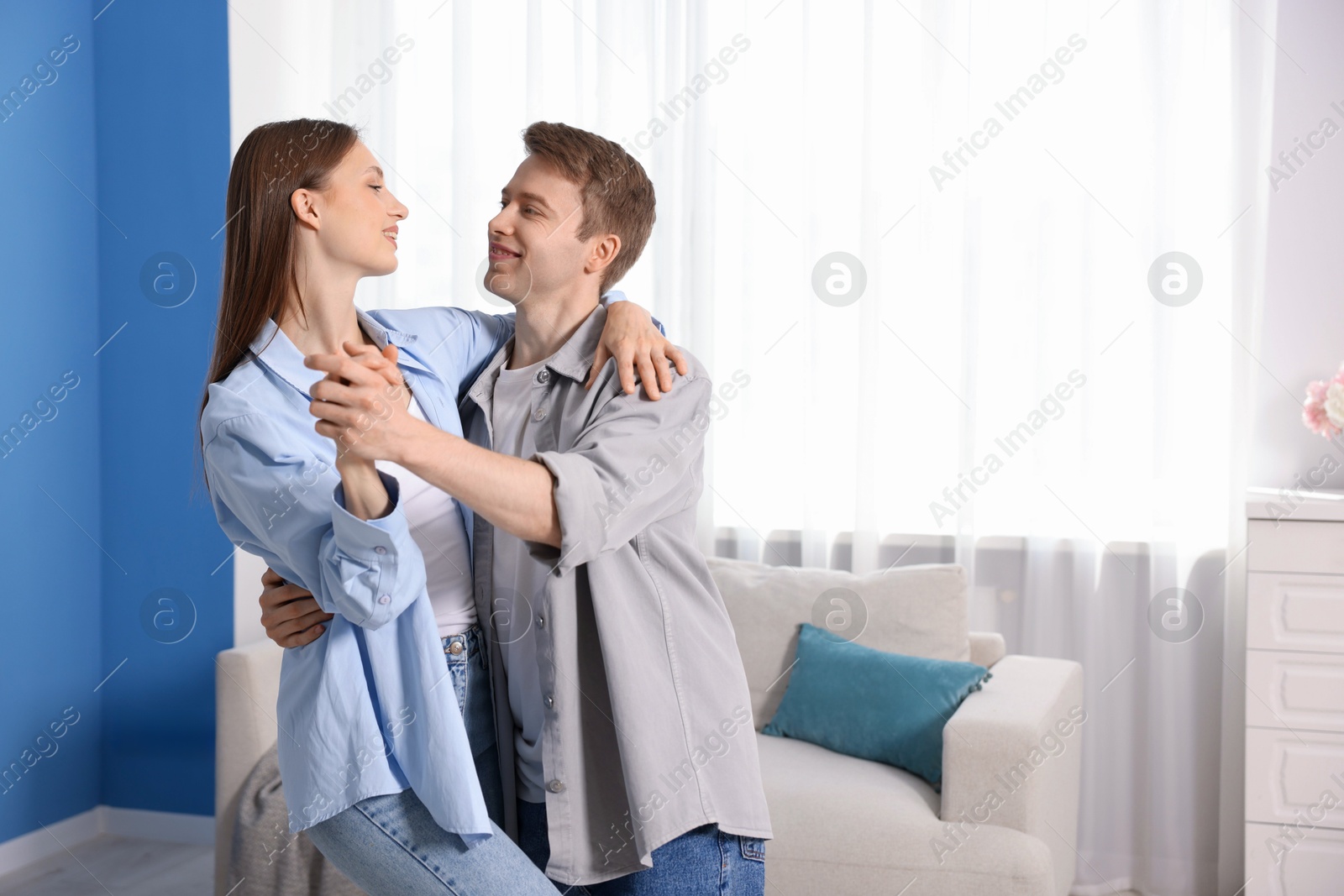 Photo of Happy couple dancing at home. Space for text