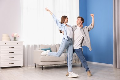 Photo of Happy young couple dancing together at home