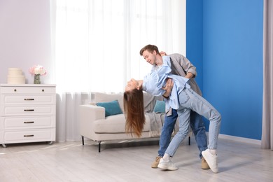 Photo of Happy young couple dancing together at home