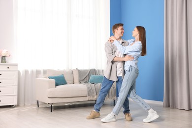 Photo of Happy young couple dancing together at home