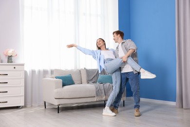Photo of Happy young couple dancing together at home