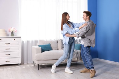 Photo of Happy young couple dancing together at home