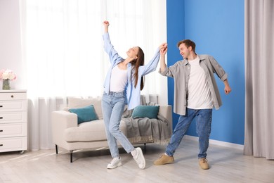 Photo of Happy young couple dancing together at home