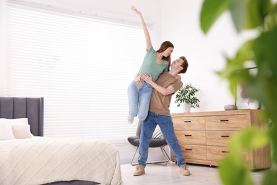 Photo of Happy young couple dancing together in bedroom