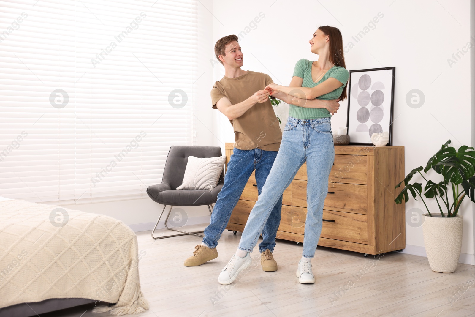 Photo of Happy young couple dancing together at home