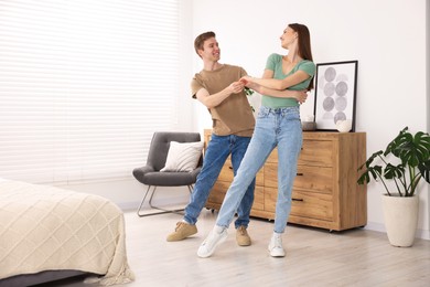 Photo of Happy young couple dancing together at home