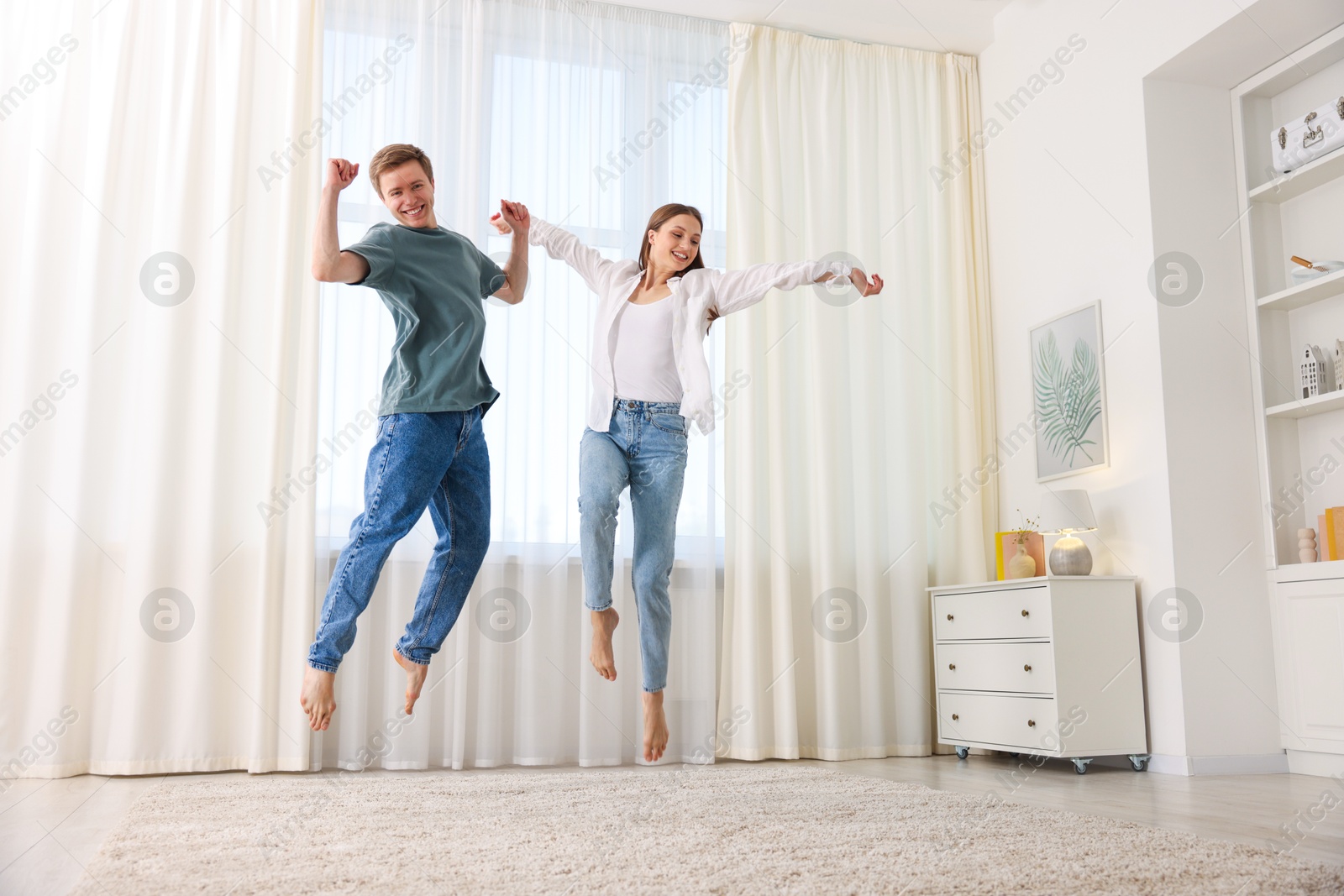 Photo of Happy young couple dancing together at home, low angle view
