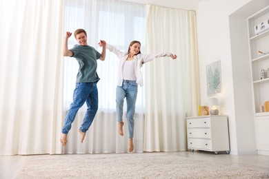 Photo of Happy young couple dancing together at home, low angle view