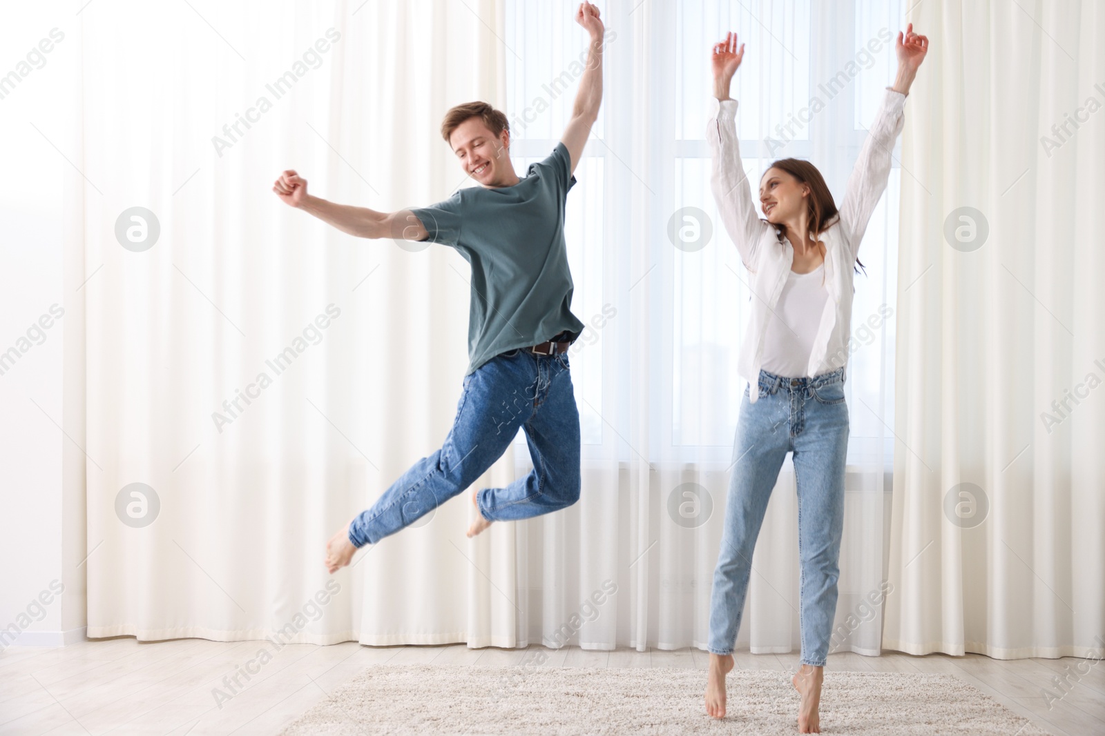 Photo of Happy young couple dancing together at home