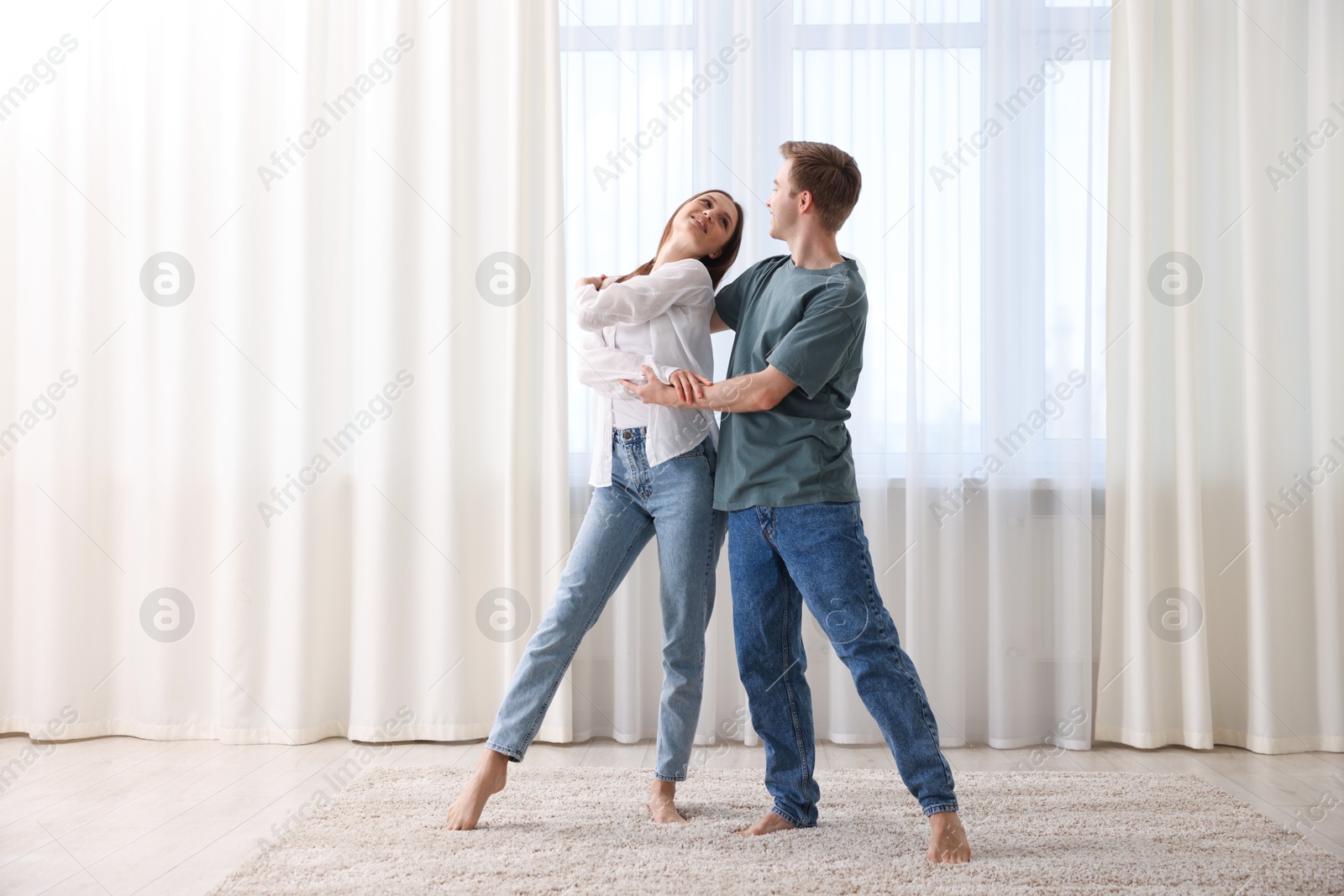 Photo of Happy young couple dancing together at home
