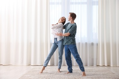 Photo of Happy young couple dancing together at home