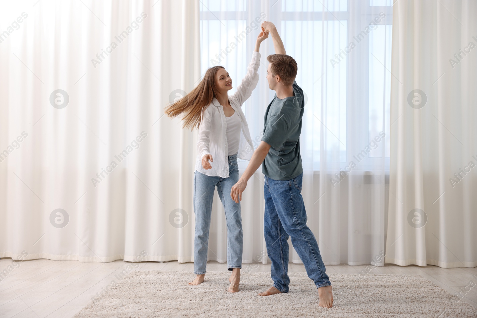 Photo of Happy young couple dancing together at home
