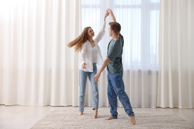 Photo of Happy young couple dancing together at home