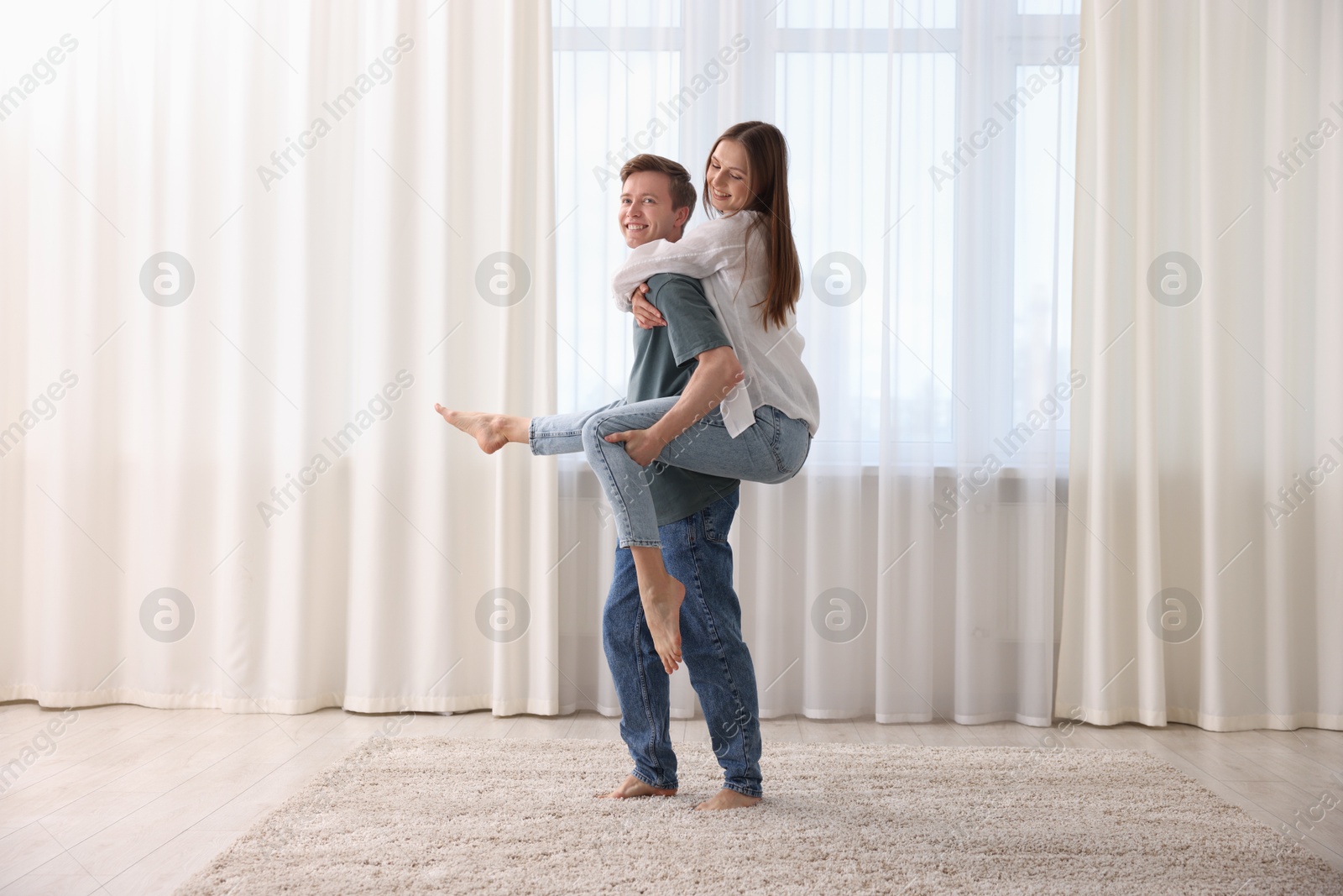 Photo of Happy young couple dancing together at home
