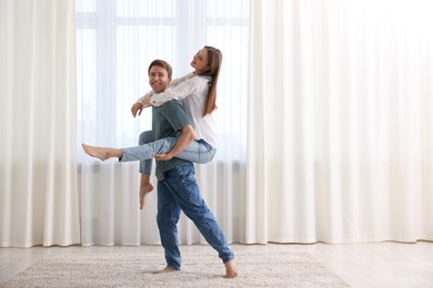 Photo of Happy young couple dancing together at home