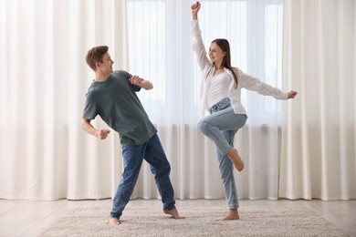 Photo of Happy young couple dancing together at home