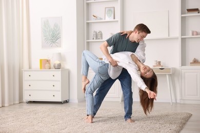 Photo of Happy young couple dancing together at home