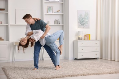 Photo of Happy young couple dancing together at home