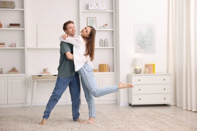 Photo of Happy young couple dancing together at home
